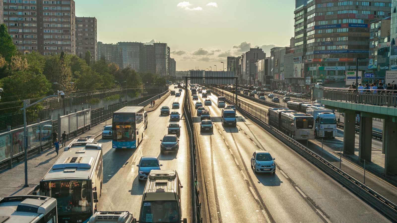 a highway filled with lots of traffic next to tall buildings